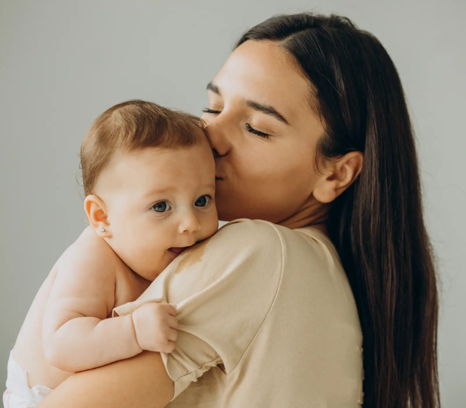 Adult holding and kissing a baby for the Bridge Helena Nursery page in Helena, Montana