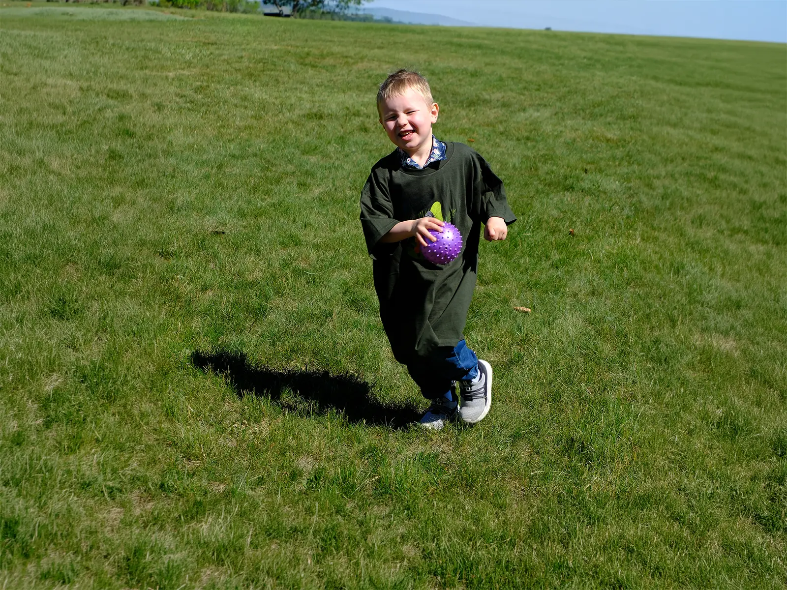 Child smiling and running on the lawn during BridgeKids ministry at Bridge Helena in Helena, Montana