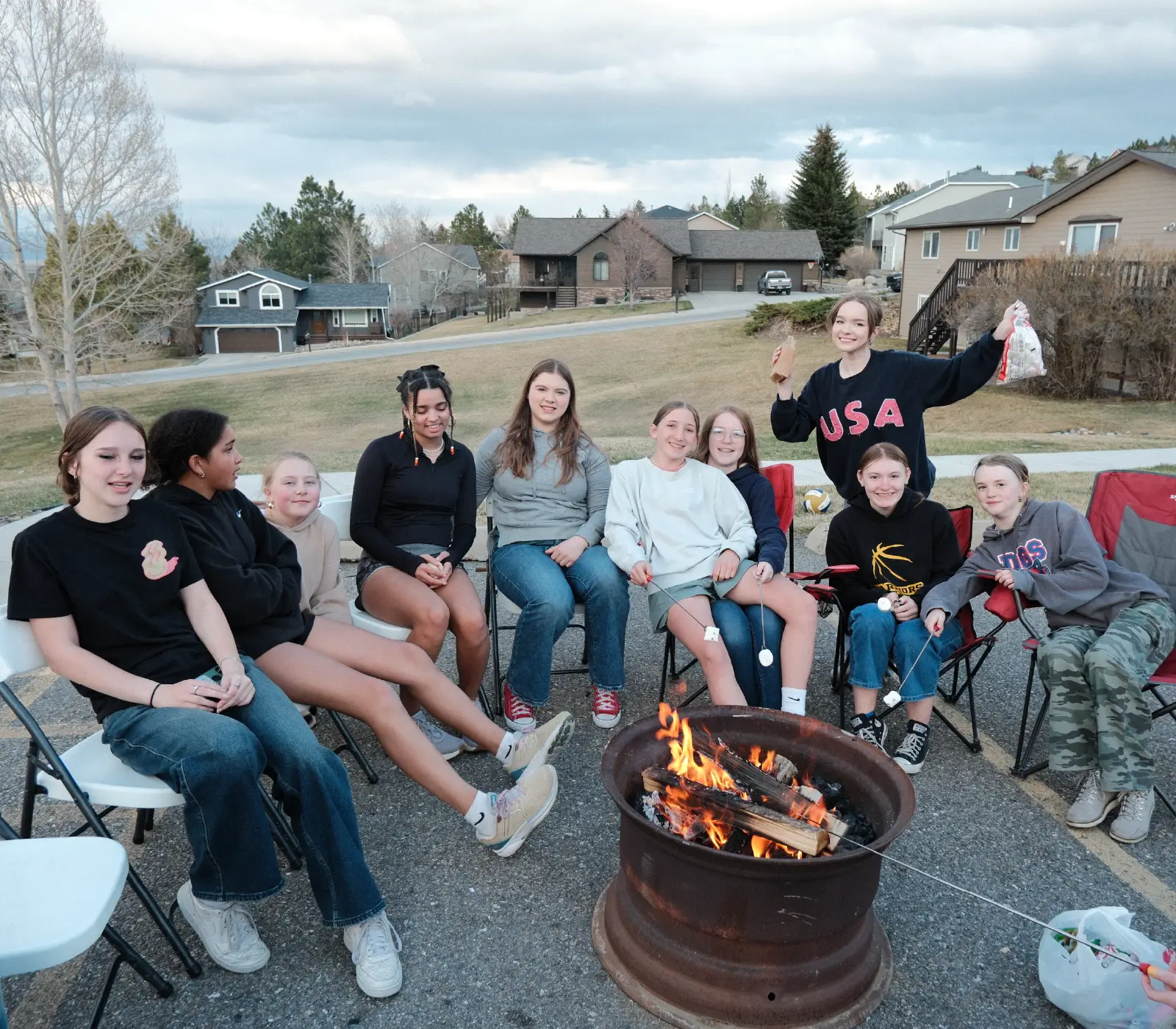 Refuge Youth students gathered around a campfire for a group hangout at Bridge Helena in Helena, Montana